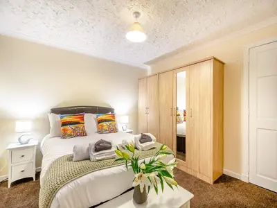 a bedroom with a large bed and a mirror at Argyle House in Rothesay