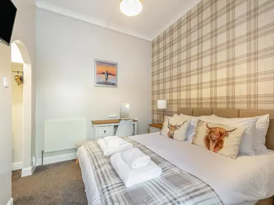 a bedroom with a large bed with white pillows at Argyle House in Rothesay