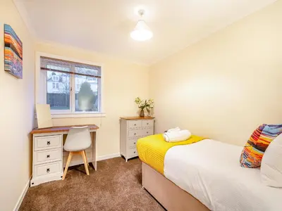 a bedroom with a desk and a bed and a chair at Argyle House in Rothesay