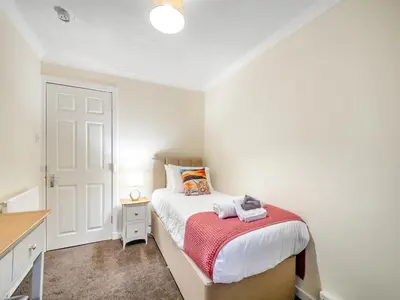 a small bedroom with a bed and a desk at Argyle House in Rothesay