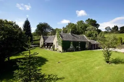 a house in a field with a green yard at Sheildaig Farm in Balloch