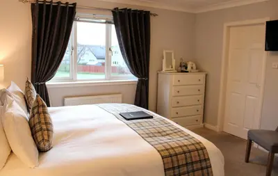a bedroom with a bed and a window at Springfield Lodge Bed and Breakfast in Stirling