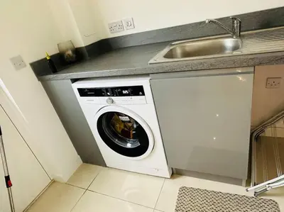 a washing machine in a kitchen next to a sink at 5 Bedroom detached House near Edinburgh Airport, City center and Murrayfield Stadium in East Calder