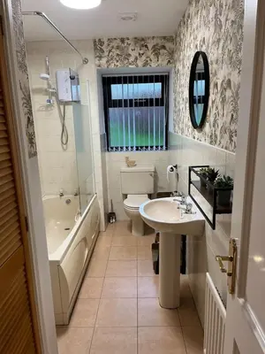 a bathroom with a tub and a sink and a toilet at Sea View Farmhouse in Cushendun