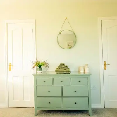 a green dresser in a room with a mirror at Sea View Farmhouse in Cushendun