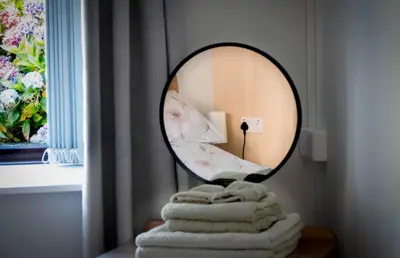 a mirror sitting on top of a table with towels at Sea View Farmhouse in Cushendun
