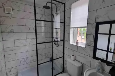 a bathroom with a shower with a toilet and a sink at 15 min drive to airport 20 min to Loch Lomond and city center in Old Kilpatrick