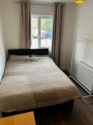 a bed in a room with a window at 15 min drive to airport 20 min to Loch Lomond and city center in Old Kilpatrick
