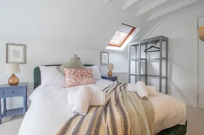 a bedroom with a large white bed with pillows at Henry Bell - Cosy 2-bedroom cottage in Helensburgh