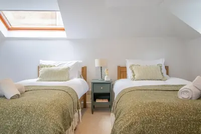 a bedroom with two beds and a window at Henry Bell - Cosy 2-bedroom cottage in Helensburgh