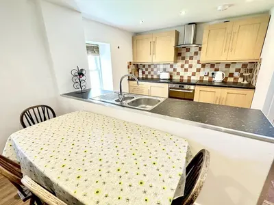 a kitchen with a sink and a table with chairs at Luxury Smugglers Cottage in the Heart of Inveraray Sleeps 4 in 2 Bedrooms in Inveraray