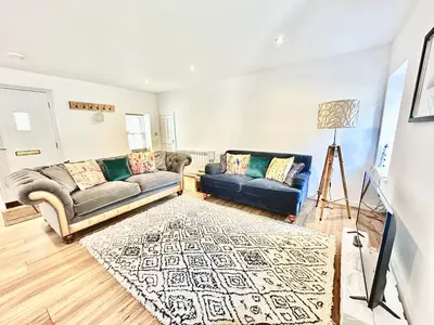 a living room with two couches and a rug at Luxury Smugglers Cottage in the Heart of Inveraray Sleeps 4 in 2 Bedrooms in Inveraray