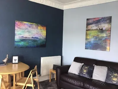 a living room with a couch and a table at Bellevue Bute, Luxury 2 bedroom sea view flat in Rothesay
