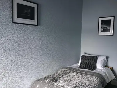 a bedroom with a bed and two pictures on the wall at Bellevue Bute, Luxury 2 bedroom sea view flat in Rothesay