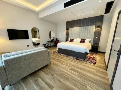a bedroom with a bed and a tv and a couch at Tynecastle Park Hotel in Edinburgh