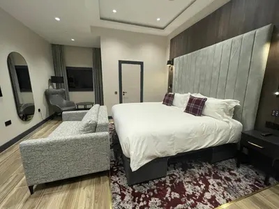 a bedroom with a bed and a couch and a chair at Tynecastle Park Hotel in Edinburgh