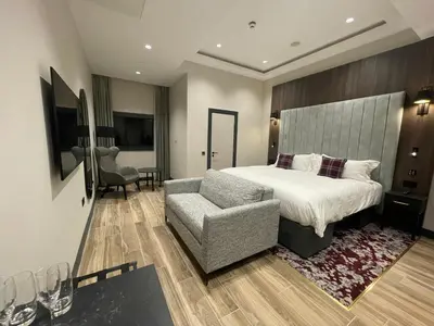 a hotel room with a bed and a chair at Tynecastle Park Hotel in Edinburgh