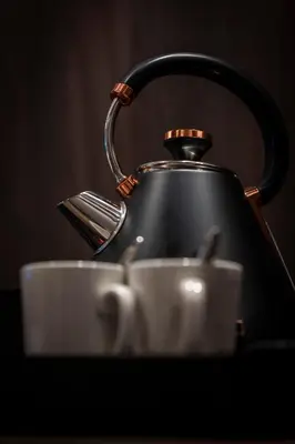 a tea kettle and two cups on a table at Tynecastle Park Hotel in Edinburgh