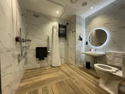 a bathroom with a shower and a toilet and a sink at Tynecastle Park Hotel in Edinburgh
