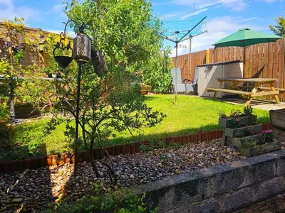 a garden with a picnic table and a tree at Spacious 2 bedroom house on the edge of Balloch in Balloch
