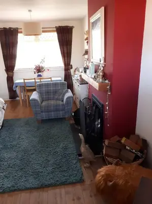 a living room with a couch a chair and a fireplace at Spacious 2 bedroom house on the edge of Balloch in Balloch