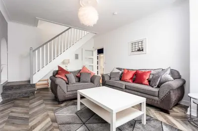a living room with two couches and a table at Berelands House - Donnini Apartments in Prestwick