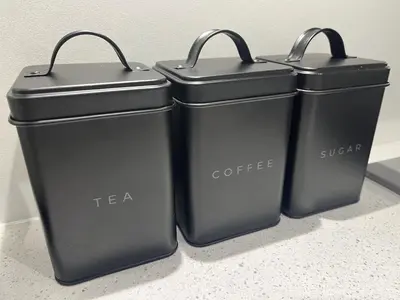 three black trash cans sitting next to a wall at The Boyd - Coorie Doon in Prestwick