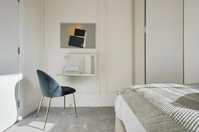 a bedroom with a blue chair next to a bed at (G1) Elegant 2 bed Blythswood Apartment in Glasgow