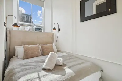 a bedroom with a bed with two lamps and a window at (G1) Elegant 2 bed Blythswood Apartment in Glasgow