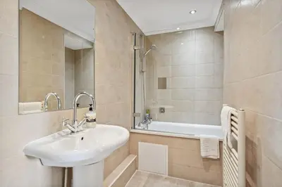 a bathroom with a sink and a bath tub at (G2) Central 1 Bed Blythswood Flat in Glasgow