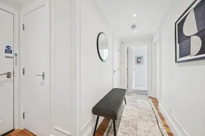 a white hallway with a bench and a mirror at (G2) Central 1 Bed Blythswood Flat in Glasgow