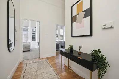 a living room with a table and a mirror at (G4) Luxurious 2 Bed Blythswood Flat in Glasgow