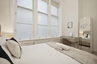 a bedroom with a large white bed with a mirror at (G4) Luxurious 2 Bed Blythswood Flat in Glasgow