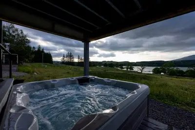 a jacuzzi tub with a view of the water at Blar Cottage (Private Sauna + Fast Starlink Wifi) in Hayfield