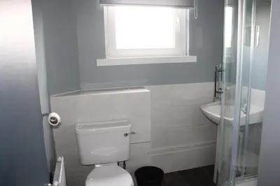 a bathroom with a toilet and a sink and a window at Garnock 1 in Beith