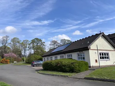 a house with a solar roof on a street at Garnock 1 in Beith