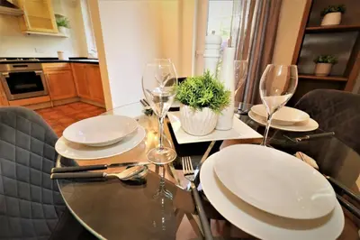 a dining table with plates and wine glasses on it at Signature - Lincoln View in Knightswood
