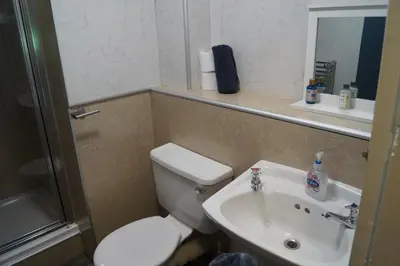 a small bathroom with a toilet and a sink at Garnock 2 in Beith