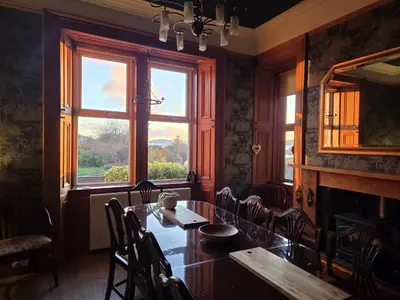 a dining room with a table and chairs and a window at The Old Rectory in Largs