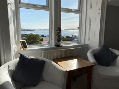 a living room with a white couch and two windows at The Old Rectory in Largs