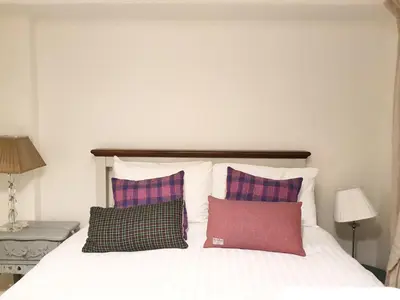 a bedroom with a bed with three pillows on it at Edinburgh 2-Bedroom Cottage with Parking - Ground Floor in Edinburgh