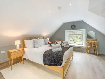 a bedroom with a large bed and a window at Blackside Cottage - A Luxury Rural Retreat in Mauchline