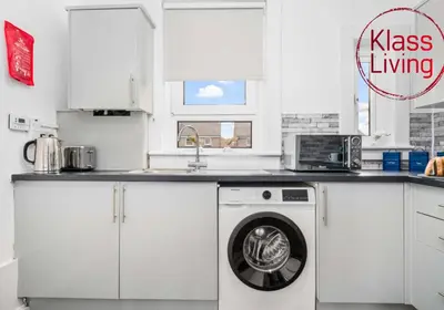 a kitchen with a washing machine and a sink at Uddingston Apartment by Klass Living in Uddingston