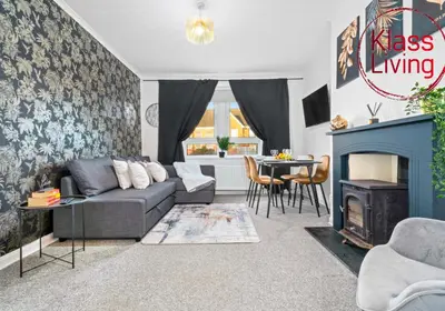 a living room with a couch and a fireplace at Uddingston Apartment by Klass Living in Uddingston