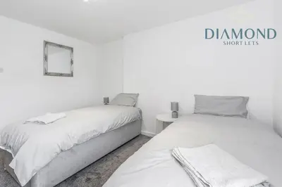 a bedroom with two beds and a small table at FOUNDRY - 2 Bedrooms, Fully Equipped, Free Parking, WiFi, FAVOURITE for Contractors, Long Stays Welcome, Food, Bars, Shops by Diamond Short Lets in Dunfermline