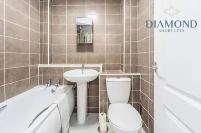 a bathroom with a toilet and a sink and a tub at FOUNDRY - 2 Bedrooms, Fully Equipped, Free Parking, WiFi, FAVOURITE for Contractors, Long Stays Welcome, Food, Bars, Shops by Diamond Short Lets in Dunfermline