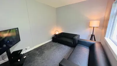 a living room with a couch and a television at Garnock 3 in Beith