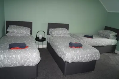 two twin beds in a room with two at Garnock 3 in Beith