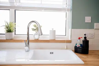 a white sink in a kitchen with a window at Otterburn House in Rothesay
