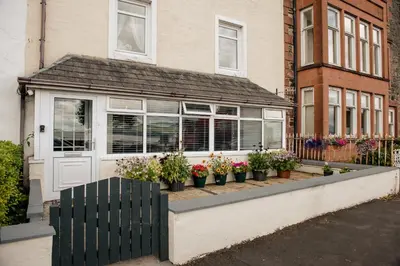 a house with potted plants in front of it at Otterburn House in Rothesay